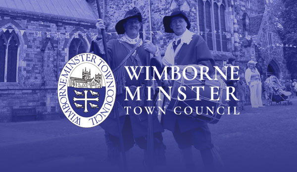 Wimborne Minster Town Council crest over re-enactors outside the Minster